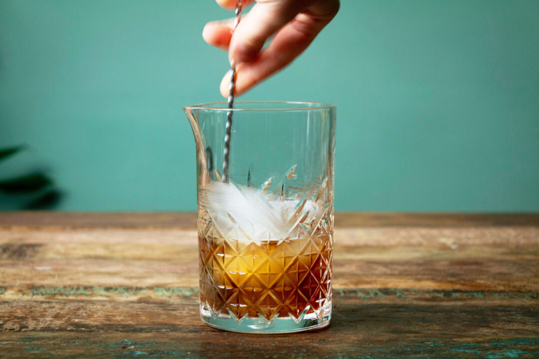 A motion photo of a Vieux Carré being stirred over ice in a stirring glass